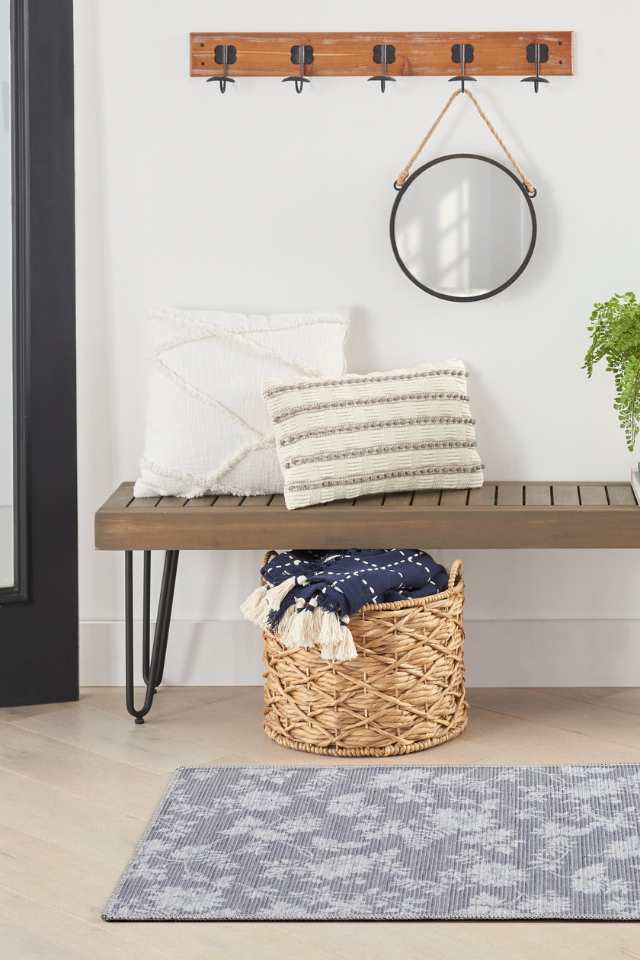 gray area rug in modern entryway with wooden bench